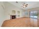 Spacious living room with a decorative fireplace and mantle, wood flooring, and sliding doors to the backyard at 4197 Bottiglia Ave, Las Vegas, NV 89141