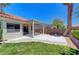 A covered back patio for outdoor living and entertaining, featuring a well-manicured lawn and a block wall at 4197 Bottiglia Ave, Las Vegas, NV 89141