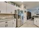Open kitchen with stainless steel refrigerator and white cabinets, flowing into the living area at 4519 Sapphire Moon Ave, North Las Vegas, NV 89084