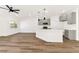 Open-concept living space featuring a kitchen with an island, gray cabinets, and wood-look floors at 4779 Straight Flush Dr # 103, Las Vegas, NV 89122
