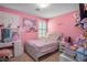 Quaint pink bedroom with a cozy bed, ample shelving, and a window with bright natural light at 4786 Castel Martini Ct, Las Vegas, NV 89147
