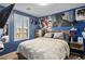 Vibrant bedroom featuring a modern rustic bed frame and natural light from a large window at 4786 Castel Martini Ct, Las Vegas, NV 89147