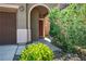 Inviting front entrance featuring an arched doorway and lush green shrubbery, great curb appeal at 4786 Castel Martini Ct, Las Vegas, NV 89147
