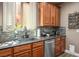 Kitchen features a stainless steel sink, granite countertops, wood cabinets, and stylish backsplash at 4786 Castel Martini Ct, Las Vegas, NV 89147