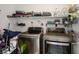 Efficient laundry room with modern washer and dryer, and ample shelving for storage at 4786 Castel Martini Ct, Las Vegas, NV 89147