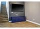 Staircase view: Features wood-look flooring, blue console, flat-screen TV, and modern design elements at 4786 Castel Martini Ct, Las Vegas, NV 89147