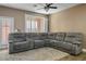 Living room with a large grey sectional sofa, wood floors, and lots of natural light at 4786 Castel Martini Ct, Las Vegas, NV 89147