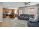 Open floor plan showcasing a gray sectional sofa, kitchen with stainless steel appliances, and hardwood floors at 4786 Castel Martini Ct, Las Vegas, NV 89147