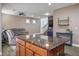 Open-concept living room with a spacious kitchen island featuring granite countertops and a comfortable gray sofa at 4786 Castel Martini Ct, Las Vegas, NV 89147