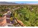 Scenic aerial shot of homes near a lush green golf course, set against a backdrop of mountains and trees at 5020 Linkside Dr, Las Vegas, NV 89130