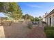Backyard with a fire pit area, mature trees, and fenced perimeter, creating a private retreat at 5020 Linkside Dr, Las Vegas, NV 89130