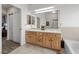 Bright bathroom featuring double sinks, ample cabinet space, and a separate tub area at 5020 Linkside Dr, Las Vegas, NV 89130