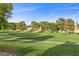 Scenic view of a lush green golf course with mature trees surrounding well-maintained homes at 5020 Linkside Dr, Las Vegas, NV 89130