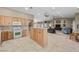 Bright kitchen featuring oak cabinets, center island, and tile flooring opening to living area at 5020 Linkside Dr, Las Vegas, NV 89130