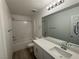 Bright bathroom featuring a shower-tub combo, white vanity, and modern lighting fixture at 5163 Capucina St # Lot 3, Las Vegas, NV 89122