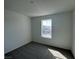 This bedroom has neutral carpet, light walls, and a window overlooking the neighborhood at 5163 Capucina St # Lot 3, Las Vegas, NV 89122
