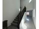 Carpeted staircase with dark wood railing and white walls leading to the second floor at 5175 Capucina St # Lot 5, Las Vegas, NV 89122