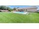 Spacious backyard with sparkling pool, covered patio, and lush green lawn, perfect for outdoor living and entertaining at 5500 Santovito St, Pahrump, NV 89061