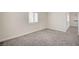A carpeted bedroom with a window and a doorway to another room at 5500 Santovito St, Pahrump, NV 89061