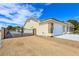 Inviting home featuring a three-car garage, secure gated driveway, and low-maintenance desert landscape at 5500 Santovito St, Pahrump, NV 89061