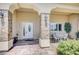 Inviting front porch featuring stone pillars, a decorative door, and an outdoor seating area at 5500 Santovito St, Pahrump, NV 89061