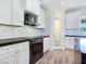 Bright kitchen boasts white cabinetry, sleek black countertops, and stainless steel appliances at 5500 Santovito St, Pahrump, NV 89061