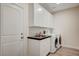 Well-lit laundry room with cabinetry, sink, and washer/dryer at 5500 Santovito St, Pahrump, NV 89061