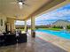 An outdoor living space features a covered patio with ceiling fans and a view of the pool at 5500 Santovito St, Pahrump, NV 89061