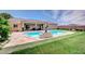 Beautiful backyard oasis with a sparkling pool and lush green lawn for outdoor enjoyment at 5500 Santovito St, Pahrump, NV 89061