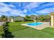 Landscaped backyard offers a private pool, lush lawn, and patio with space for outdoor activities at 5500 Santovito St, Pahrump, NV 89061