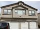 Two-story home with three-car garage and stucco exterior under cloudy sky at 6462 Saddle Up Ave # 103, Henderson, NV 89011