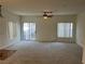Bright living room with neutral carpet, ceiling fan, and sliding glass door at 6462 Saddle Up Ave # 103, Henderson, NV 89011