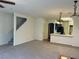 Open-concept living room with neutral carpet, adjacent kitchen, and stairway at 6462 Saddle Up Ave # 103, Henderson, NV 89011