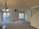 Spacious living room with neutral carpet, ceiling fan, and sliding glass door at 6462 Saddle Up Ave # 103, Henderson, NV 89011