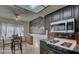 Well-lit kitchen featuring sleek black cabinetry, stainless steel microwave, and a modern backsplash at 6463 Big Pine Way, Las Vegas, NV 89108