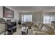 Inviting living room featuring plush sofas, a television, and a large window allowing natural light at 6463 Big Pine Way, Las Vegas, NV 89108