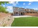 Expansive backyard with lush lawn, attractive rock landscaping, and brick-paved patio extending from the home's rear at 6783 Pleasant Flower St, Las Vegas, NV 89149