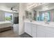 Bright bathroom with double sinks, vanity with white cabinets, and a view to the main bedroom at 6783 Pleasant Flower St, Las Vegas, NV 89149