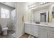 Bathroom with double sinks, white cabinets, a toilet and a shower with a curtain at 6783 Pleasant Flower St, Las Vegas, NV 89149