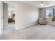 Spacious carpeted bedroom with ceiling fan, gray walls, a window and an upholstered chair at 6783 Pleasant Flower St, Las Vegas, NV 89149