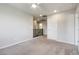 Open carpeted space with white walls and trim, a ceiling fan and views to the hallway and stairway at 6783 Pleasant Flower St, Las Vegas, NV 89149