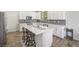 This stylish kitchen features white cabinets, mosaic backsplash, stainless steel appliances and an island with barstool seating at 6783 Pleasant Flower St, Las Vegas, NV 89149