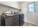 Modern laundry room featuring front loading washer and dryer, light wood floor and large white shelf above at 6783 Pleasant Flower St, Las Vegas, NV 89149
