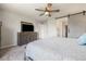 This expansive main bedroom features a large television, ceiling fan and sliding barn door at 6783 Pleasant Flower St, Las Vegas, NV 89149