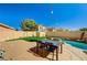 Beautiful backyard with artificial turf, dining area, and pool, providing a perfect outdoor oasis at 74 Harbor Coast St, Las Vegas, NV 89148