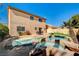 Stunning backyard showcasing a rock-rimmed pool, lush green lawn, and inviting outdoor dining area at 74 Harbor Coast St, Las Vegas, NV 89148