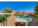Inviting backyard featuring a custom pool with rock features, complemented by a spacious patio and lush greenery at 74 Harbor Coast St, Las Vegas, NV 89148
