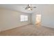 Bright bedroom featuring a ceiling fan, carpet flooring, and an ensuite bathroom with a window at 74 Harbor Coast St, Las Vegas, NV 89148