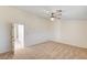 Large bedroom with carpet flooring, ceiling fan, and a doorway leading to the hallway at 74 Harbor Coast St, Las Vegas, NV 89148