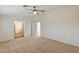 Large bedroom featuring plush carpeting, a ceiling fan and open doorway to a hallway at 74 Harbor Coast St, Las Vegas, NV 89148
